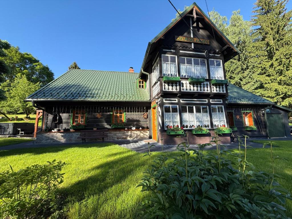 an old house with a green roof and a yard at Dom Szklarski Kamień in Szklarska Poręba