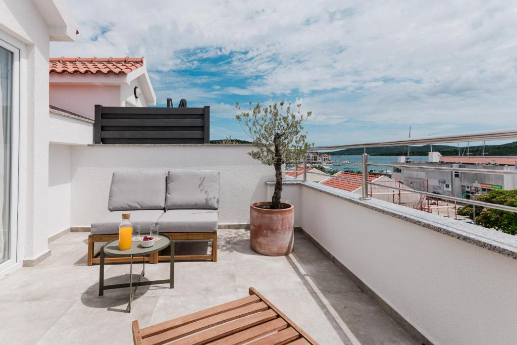 a balcony with a chair and a table at Babin bed&breakfast in Pirovac