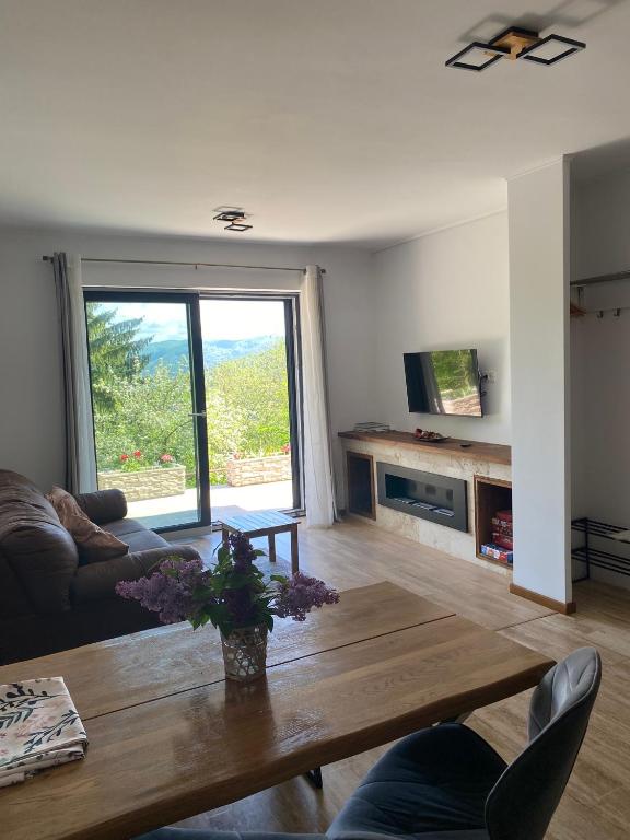 a living room with a table and a large window at Stone Apartment with sauna Sinaia in Sinaia