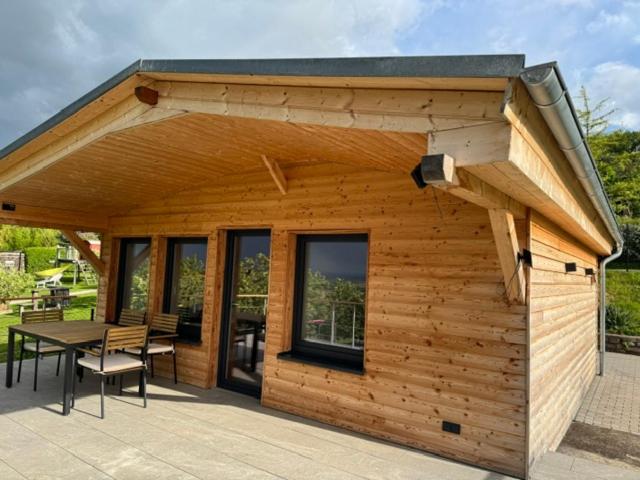 a small wooden building with a table on a patio at Panorama Chalet Fahner Höhe nahe Erfurt mit Klimaanlage in Witterda