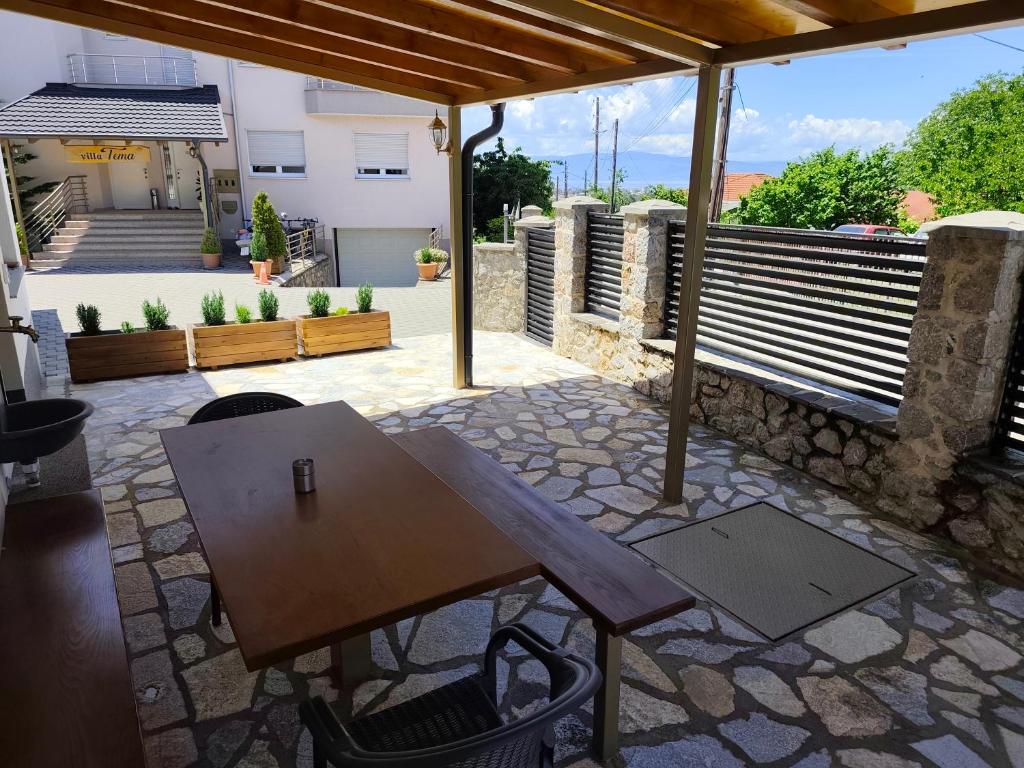 a wooden table on a patio with a roof at villa Tema 2 in Ohrid