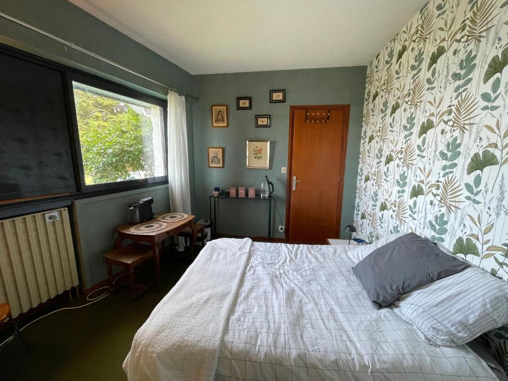 a bedroom with a bed and a window and a table at Chambre à louer face a la plage de Beaumer in Carnac
