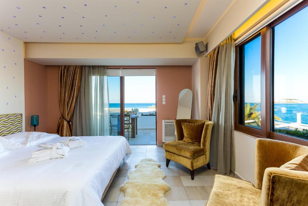 a hotel room with a bed and a balcony at Cavo Seaside Suites in Rethymno