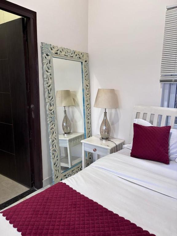 a bedroom with a white bed and a mirror at new vintage penthouse in Bhowāli