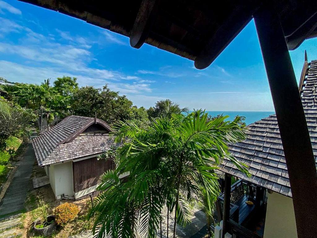 a view of a house with a palm tree and the ocean at Sea view apartments in Nathon Bay