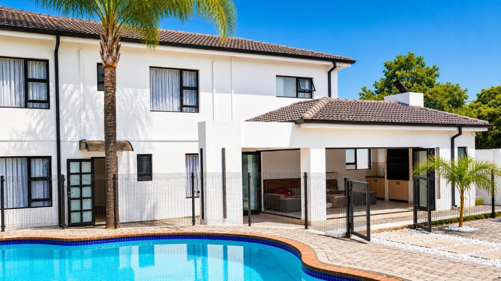 a house with a swimming pool in front of it at Regent Heights Hotel in Johannesburg