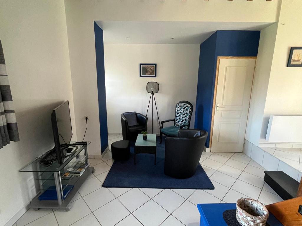 a living room with a couch and a tv at Le champ de l alouette in Bec-de-Mortagne