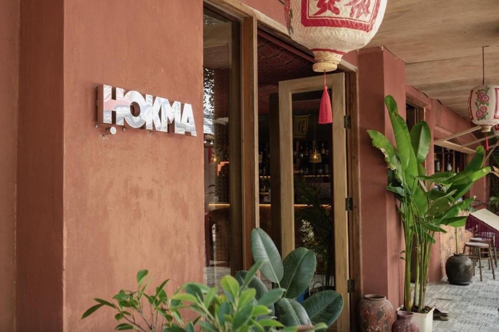 a restaurant with a sign on the side of a building at Ḥokma Boutique Hotel & Tropical Lounge in Phi Phi Islands