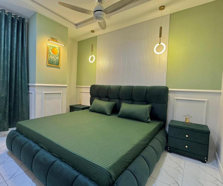 a bedroom with a large bed with a green headboard at Gulberg Greens Islamabad in Islamabad