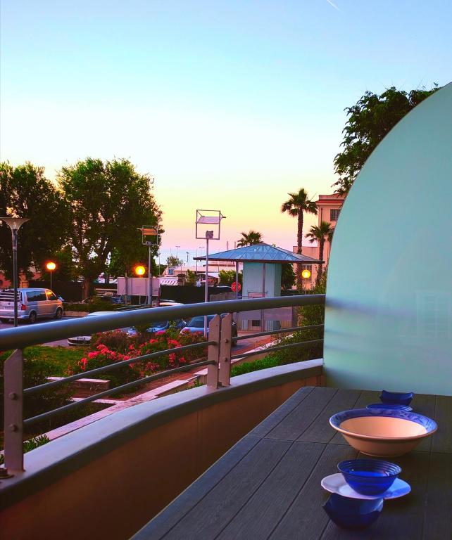a wooden table with two blue bowls on a balcony at VistaMare Bluemar - Garden & Sea in Cattolica