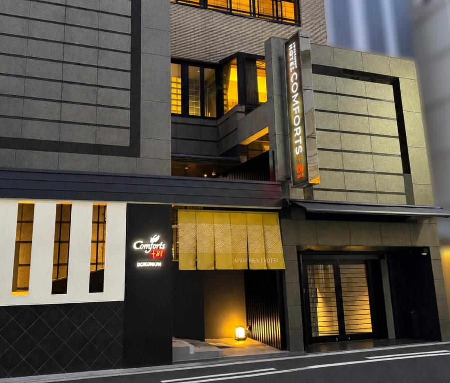a building with a sign on the side of it at Comforts81 DOTONBORI in Osaka