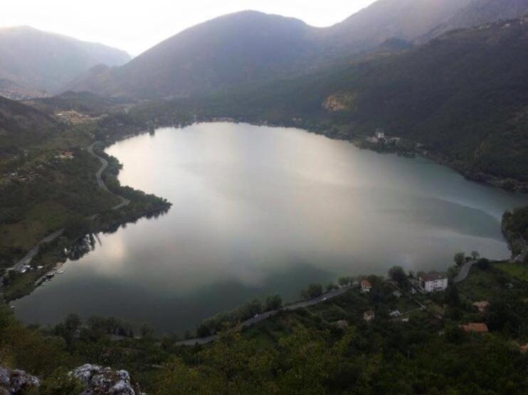 an aerial view of a large lake in a valley at Xenìa in Villalago