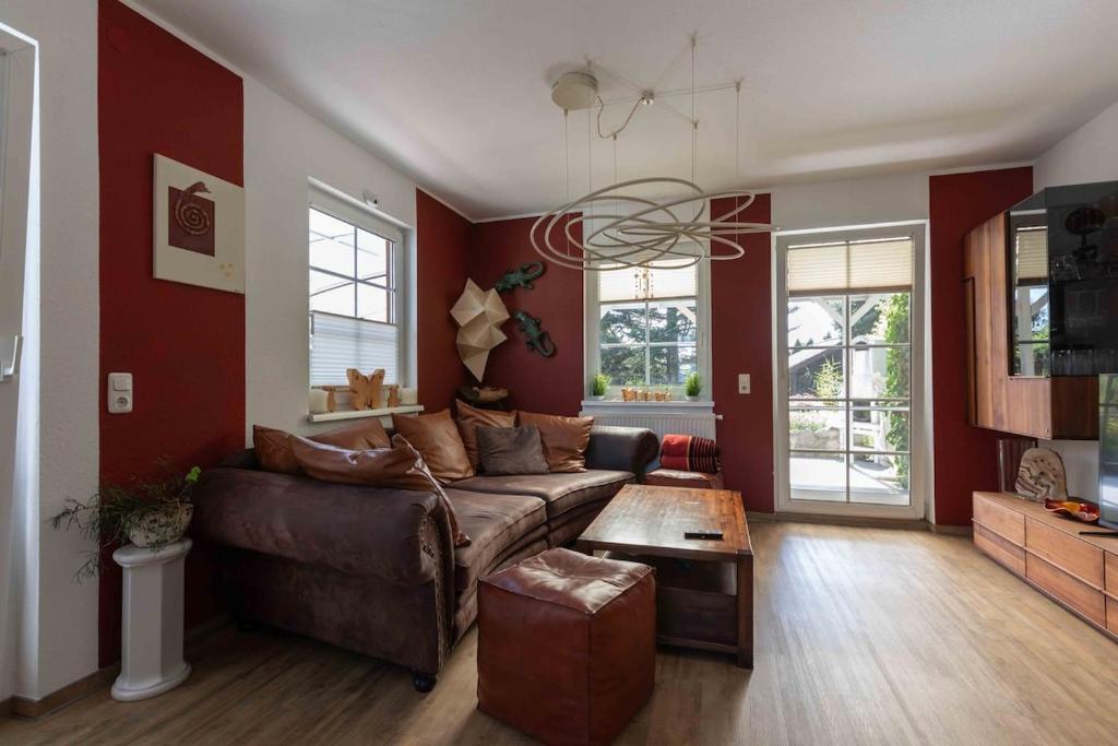 a living room with a brown couch and red walls at Ferienhaus Bergblick in Redlham