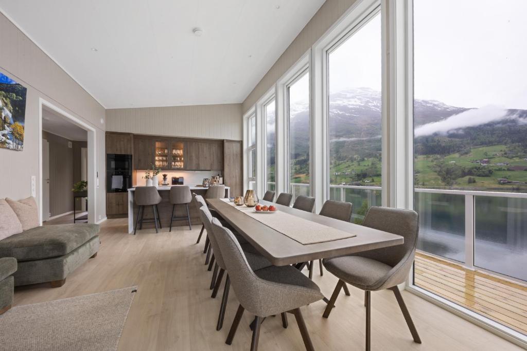 a dining room with a table and chairs and windows at Olden Fjord View in Olden