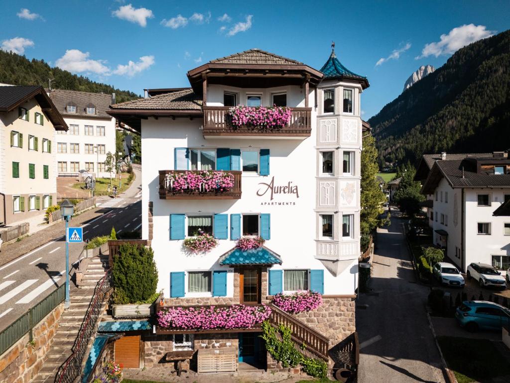 a building in a town with flowers on the balconies at Villa Aurelia in Ortisei
