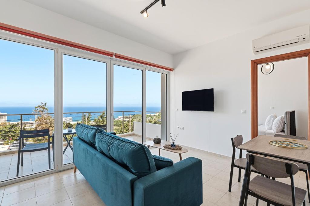 a living room with a blue couch and a table at Celestial Luxury Residences in Asgourou