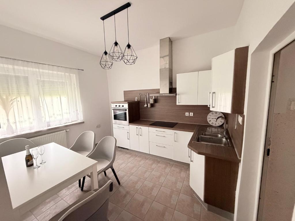 a kitchen with white cabinets and a table and chairs at Villa Kraker in Muta