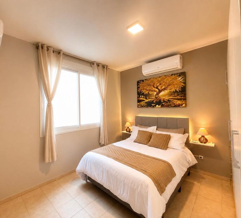 a bedroom with a large bed and a window at Apto no centro - Praça Mini Golf - Sacada - Garagem - 300m do Mar - Térreo in Capão da Canoa