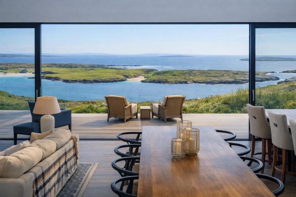 a living room with a couch and a table at Luxury Glass Villa with Hot Tub & Sea Views - Connemara in Roundstone