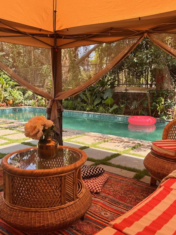 a tent with a table and a swimming pool at Big Pvt Pool & Garden 3BHK Villa, Morjim Beach 10-14mts in Siolim