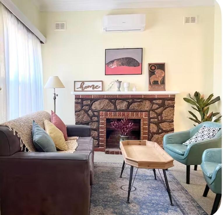 a living room with a couch and a fireplace at My River Retreat-Peaceful Murray River Escape in Murray Bridge