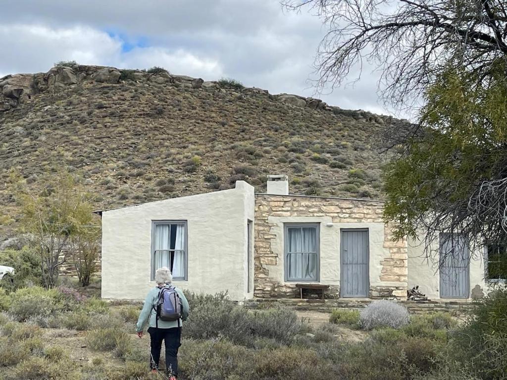 a person standing in front of a stone house at From Valle Hideaway in Tankwa in Sutherland