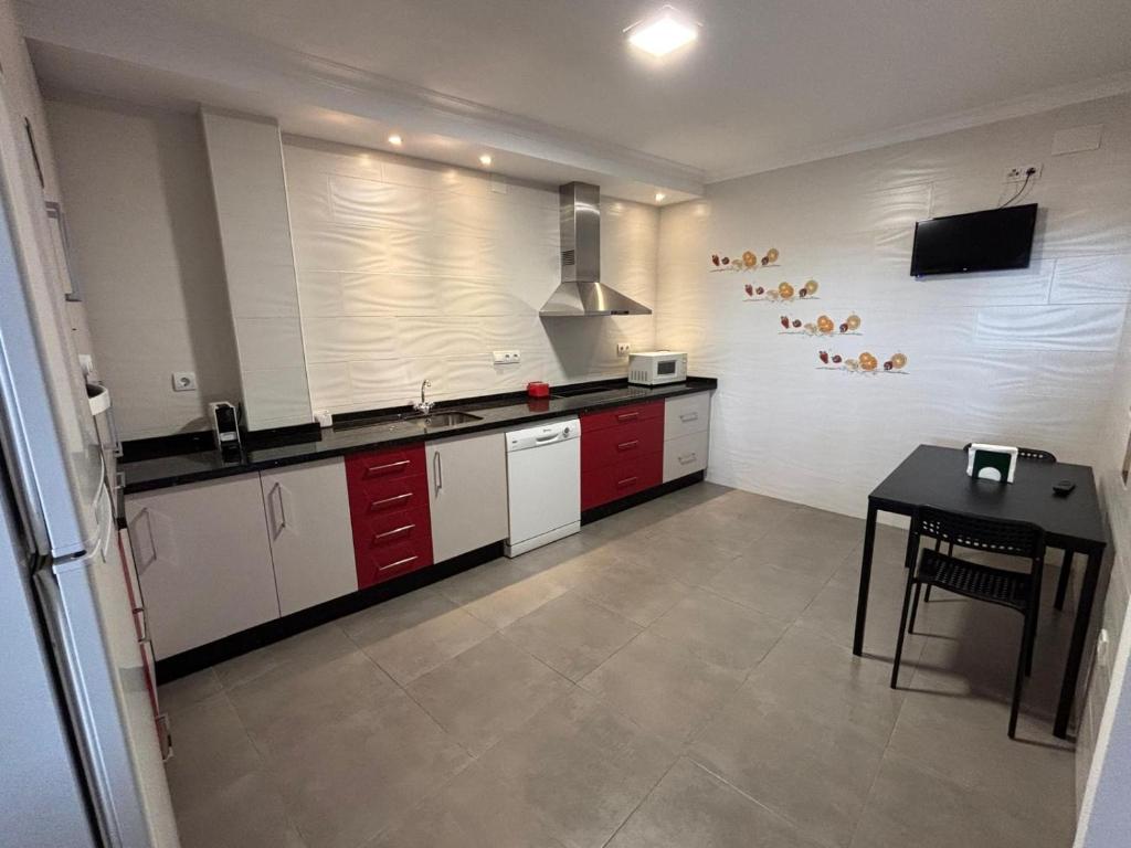 a kitchen with red and white cabinets and a table at Casa Paula Ardales caminito del Rey in Ardales