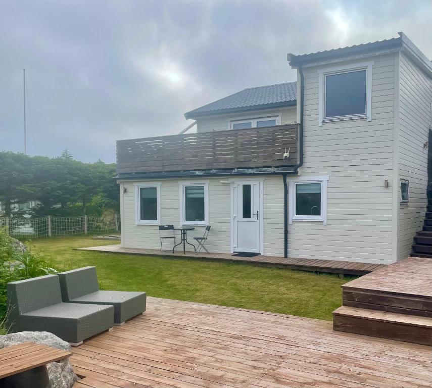 a white house with a patio and a table at Apartment Frøya in Sætra