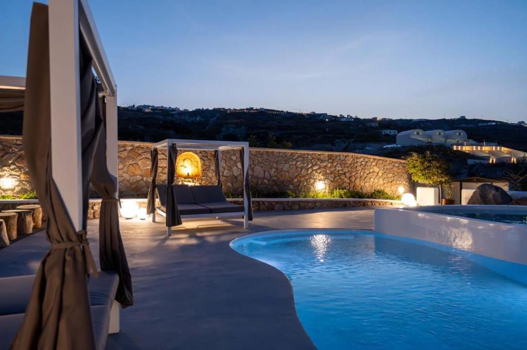 a patio with a swimming pool at night at Maison Palms in Mesaria