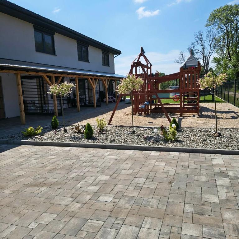 a playground in a yard next to a building at Kameralne Kładno in Łopienica