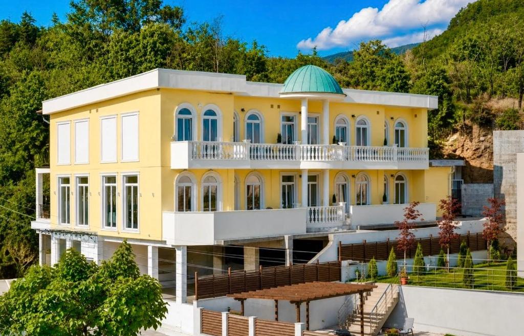 a yellow building with a green dome on top at Aleksov Complex Sans Souci in Ognyanovo