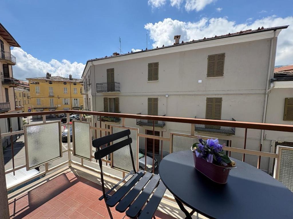 a table and a chair on a balcony at Appartamento Iris in Torre Pellice