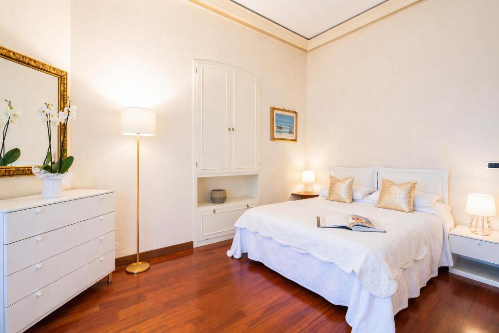 a bedroom with a white bed with a dresser and a mirror at VILLA EUGENIA - Luxury Flat in the Centre, with Parking Space in Bordighera