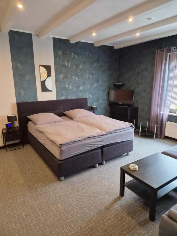 a bedroom with a large bed and a couch at Zur schönen Aussicht in Langenfeld