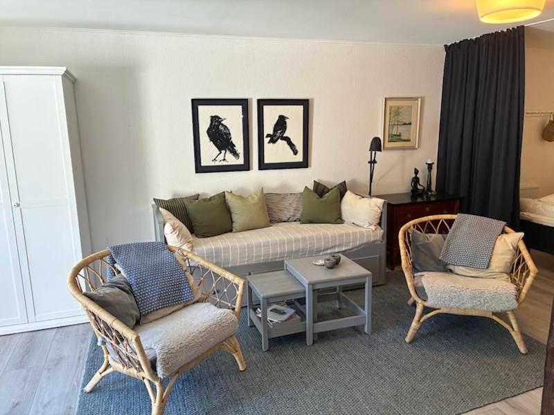 a living room with a couch and two chairs at Enkelheten i Kivik in Kivik