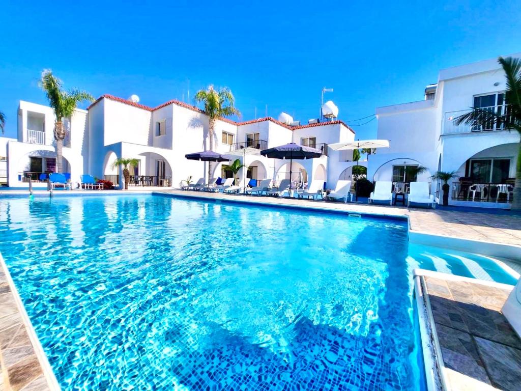a swimming pool in front of a villa at Florence Hotel Apartments in Ayia Napa
