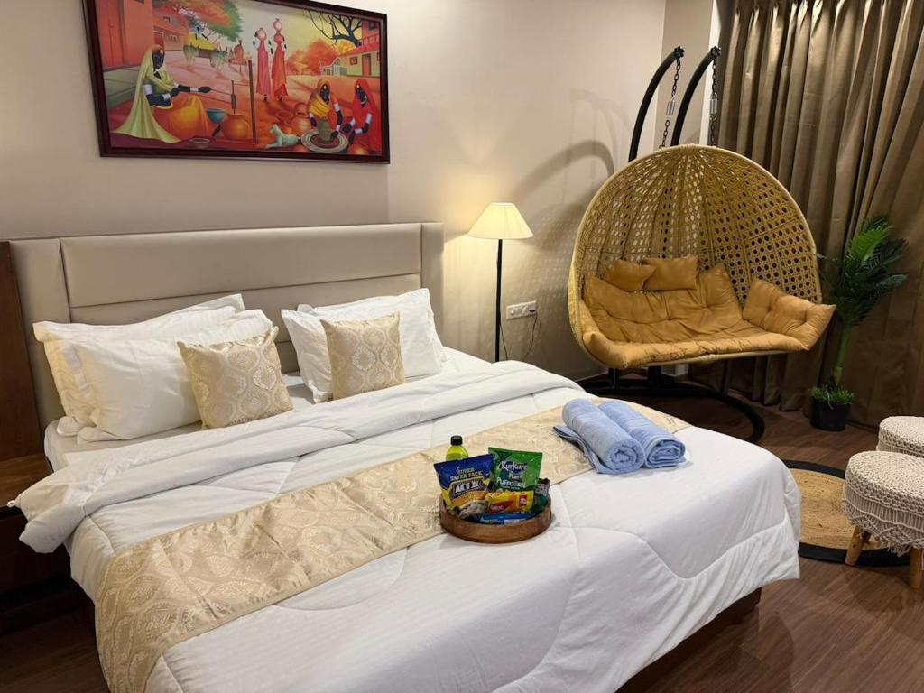 a hotel room with two beds and a chair at Luxury Swing Suite - Bliss Suites in Greater Noida