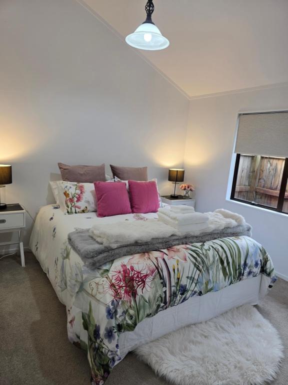 a bedroom with a large bed with pink pillows at Changing Seasons in Cambridge