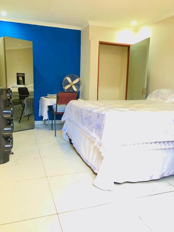 a bedroom with a large bed and a blue wall at A Great Guest House Grootfontein in Groutfontein