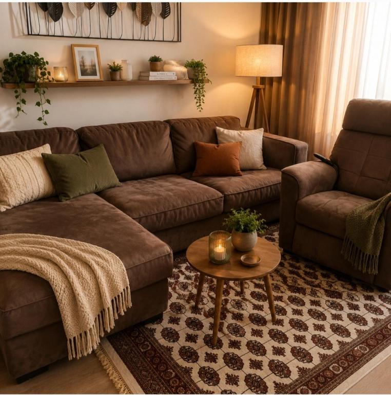 a living room with a brown couch and a table at Euforia Ma Apartment Sarajevo in Sarajevo