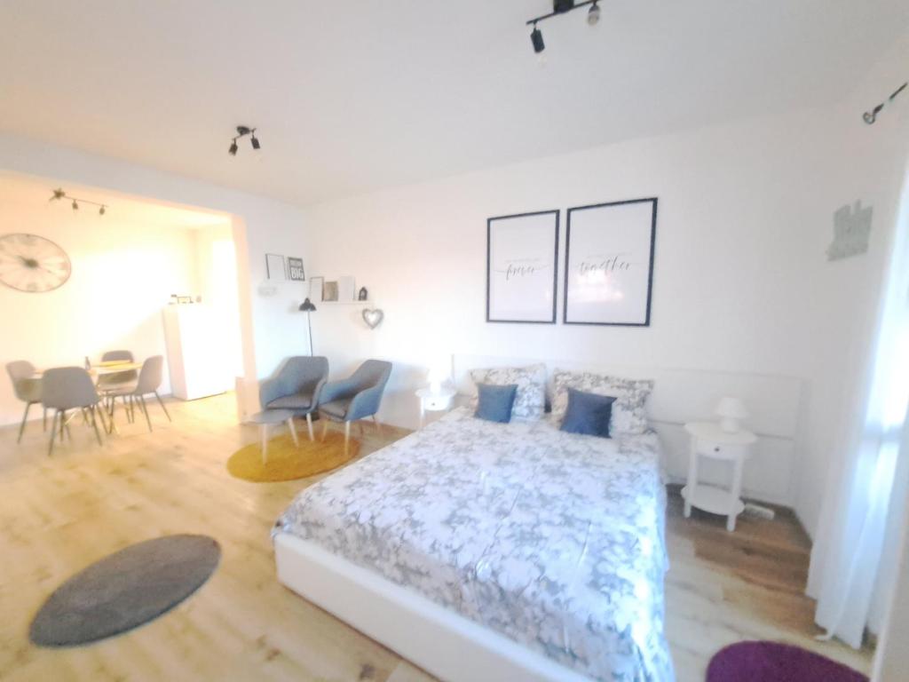 a bedroom with a bed with blue pillows and chairs at Apartman Karmen in Vodice
