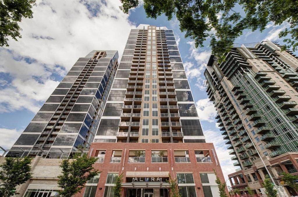 a tall building with two tall buildings at Monki Di Executive Suites - Alura in Calgary