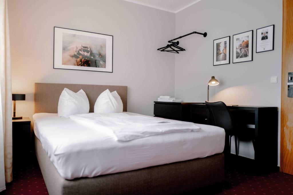 a hotel room with a bed and a desk at Landhaus Stümpelstal in Marburg an der Lahn