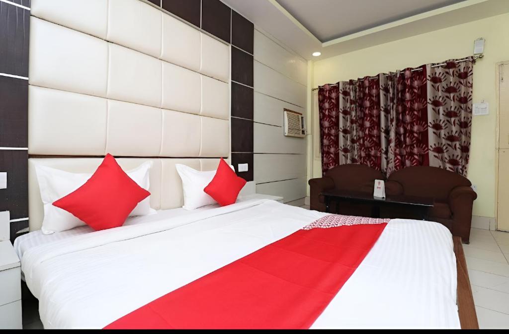 a bedroom with a large bed with red pillows at Hotel Neelkanth in Lucknow