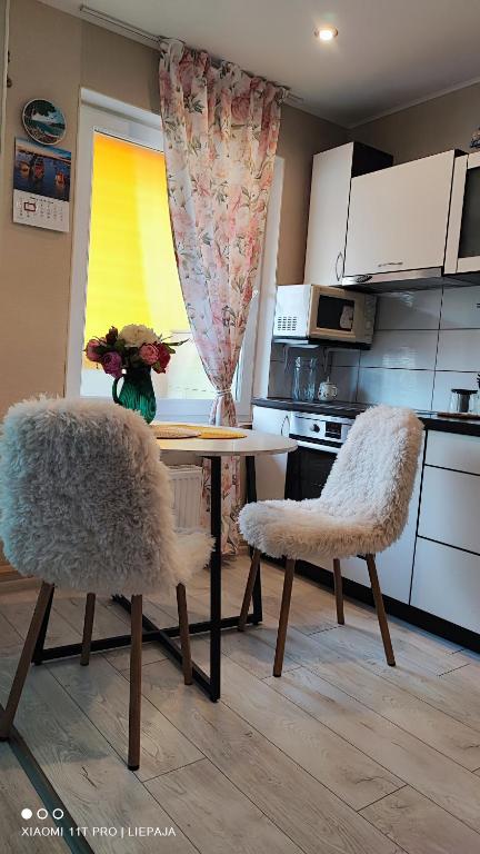 a kitchen with a table with two chairs and a tableasteryasteryasteryasteryastery at Liepaja Beach in Liepāja