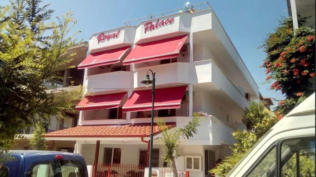 a building with red awnings on the side of it at Royal Palace in Olympic Beach