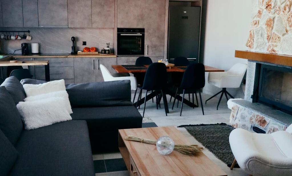 a living room with a couch and a fireplace at Mountain Aura - Stylish Escape in Kamarítsa