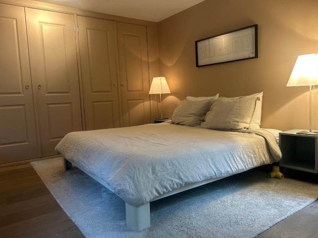 a bedroom with a bed with white sheets and pillows at Cozy room just outside Utrecht Center, calm & green in Utrecht