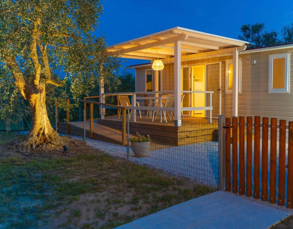 a home with a deck with a pergola at Agricamping L'Ibisco in Riotorto