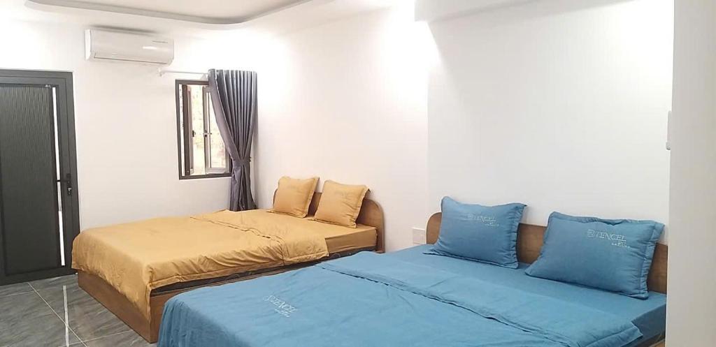a bedroom with two beds with blue pillows at COMIC 2 Homestay in Danang